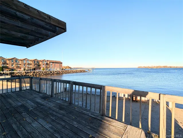 a roof deck with wooden floor and fence