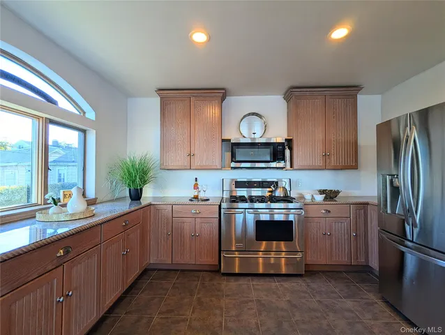 a kitchen with stainless steel appliances a sink cabinets and a window