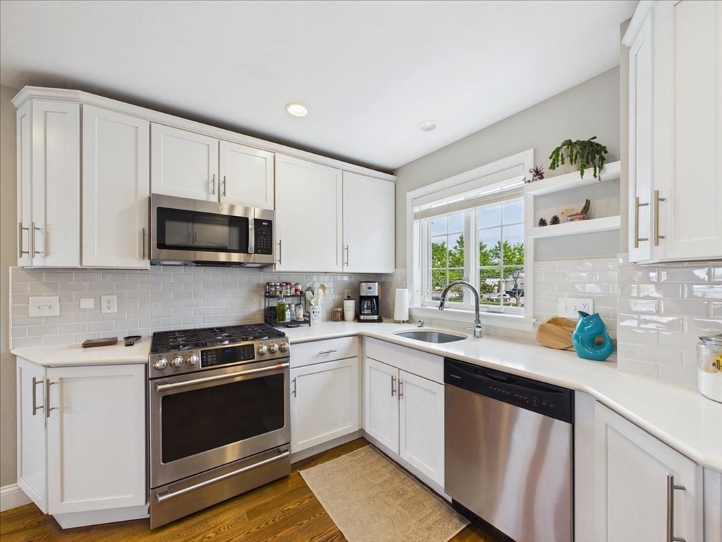 7 Bay Street, Unit 3 Hull, MA 02045 - Photo 14 of 40 a kitchen with white cabinets appliances a sink and a window