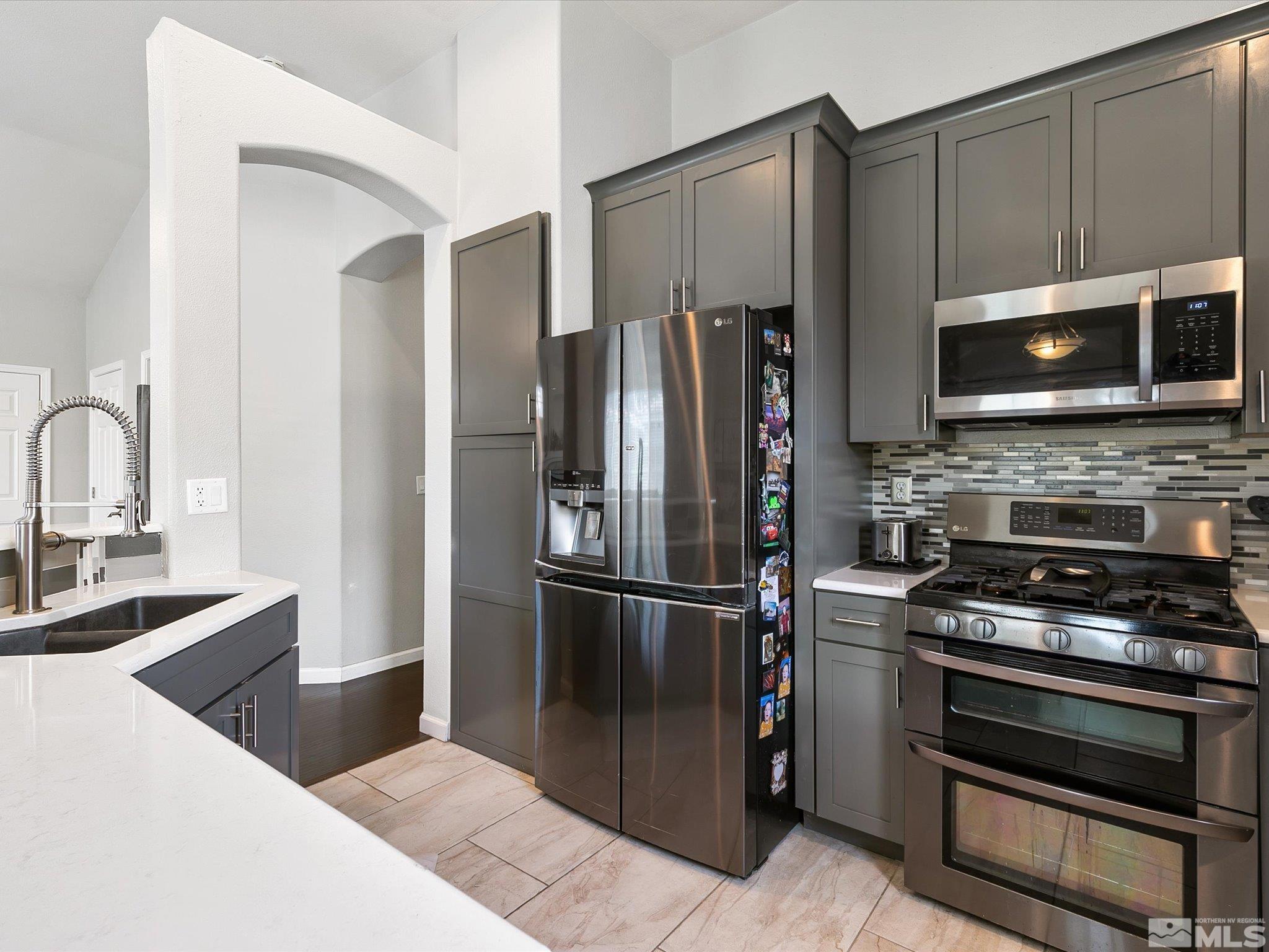 9740 Ripple Way Reno, NV 89521 - Photo 8 of 19 a kitchen with granite countertop a refrigerator and a stove top oven