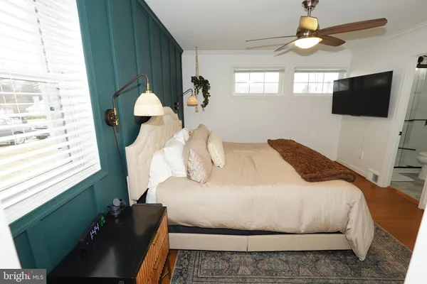a bedroom with a large bed and a flat tv screen