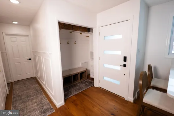 a view of a hallway with wooden floor and closet