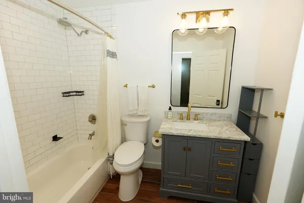 a bathroom with a granite countertop sink toilet and shower