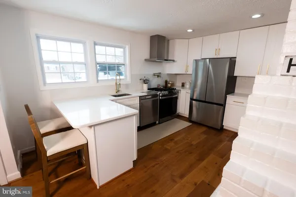 a kitchen with stainless steel appliances granite countertop a refrigerator stove microwave and sink