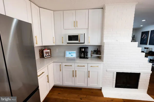 a kitchen with stainless steel appliances white cabinets and a refrigerator