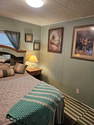 a bedroom with a bed and a painting on the wall