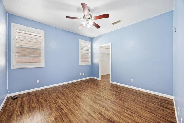 a view of room with wooden floor and ceiling fan