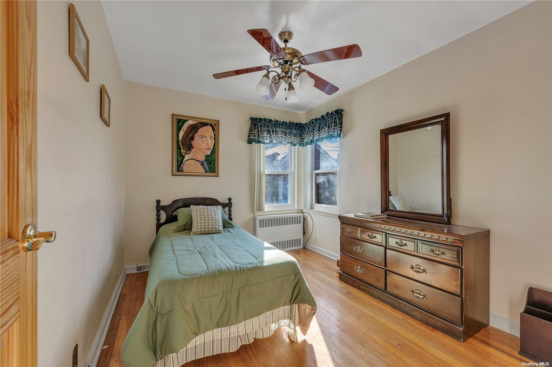 166-40 15th Drive Queens, NY 11357 - Photo 11 of 28 a bedroom with furniture and a flat screen tv