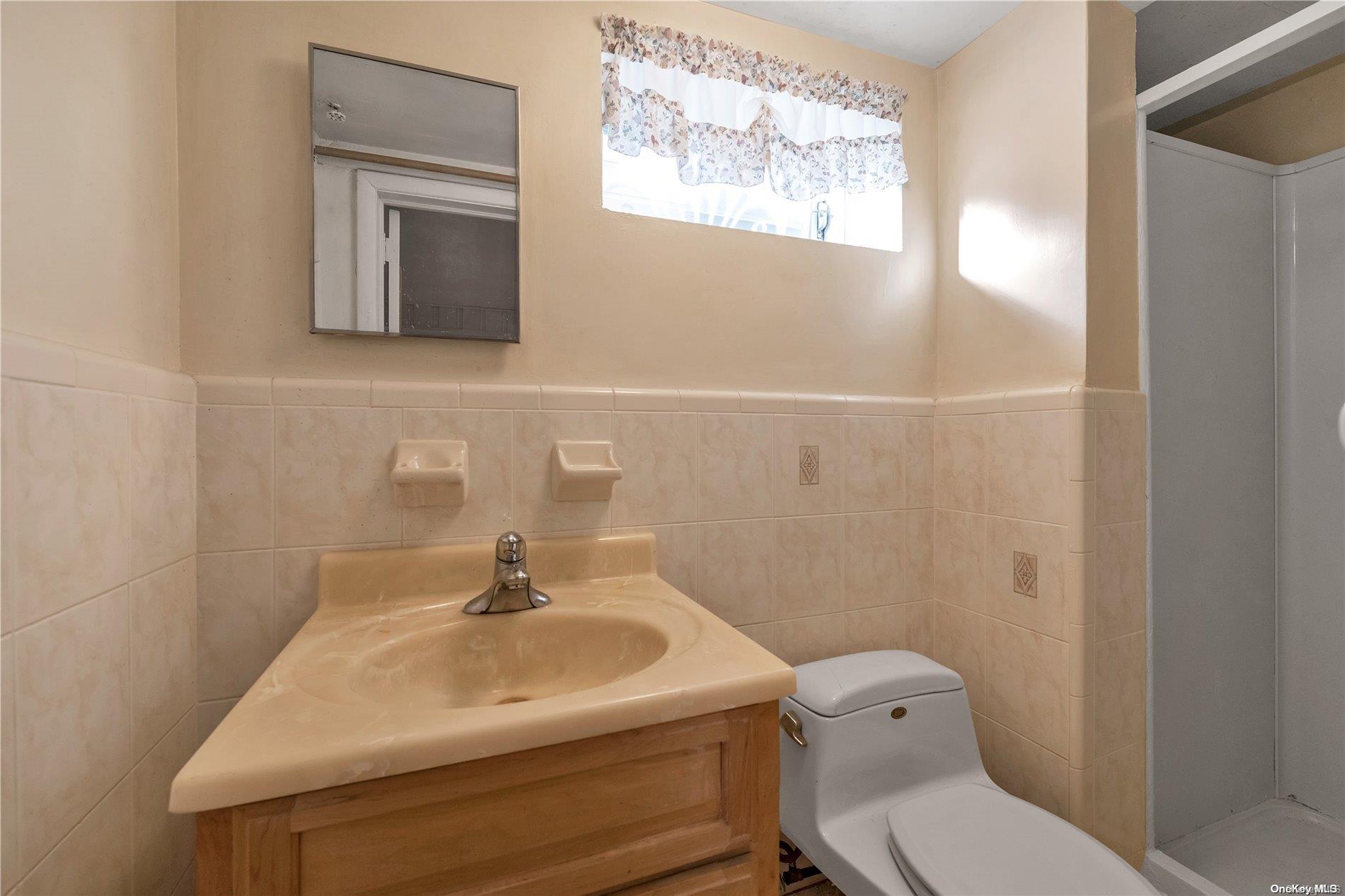 166-40 15th Drive Queens, NY 11357 - Photo 14 of 28 a bathroom with a toilet sink and mirror