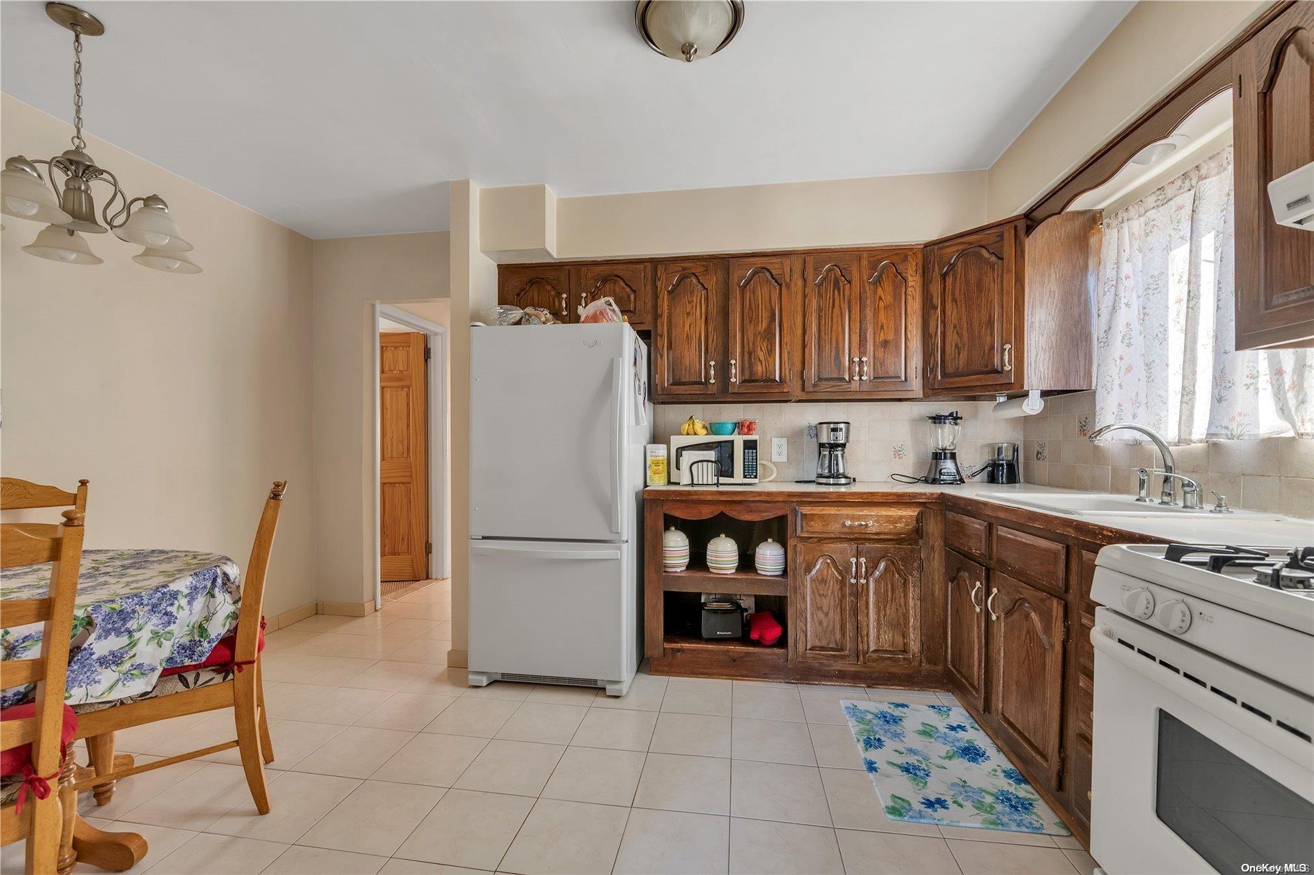 166-40 15th Drive Queens, NY 11357 - Photo 19 of 28 a kitchen with a refrigerator and a stove top oven