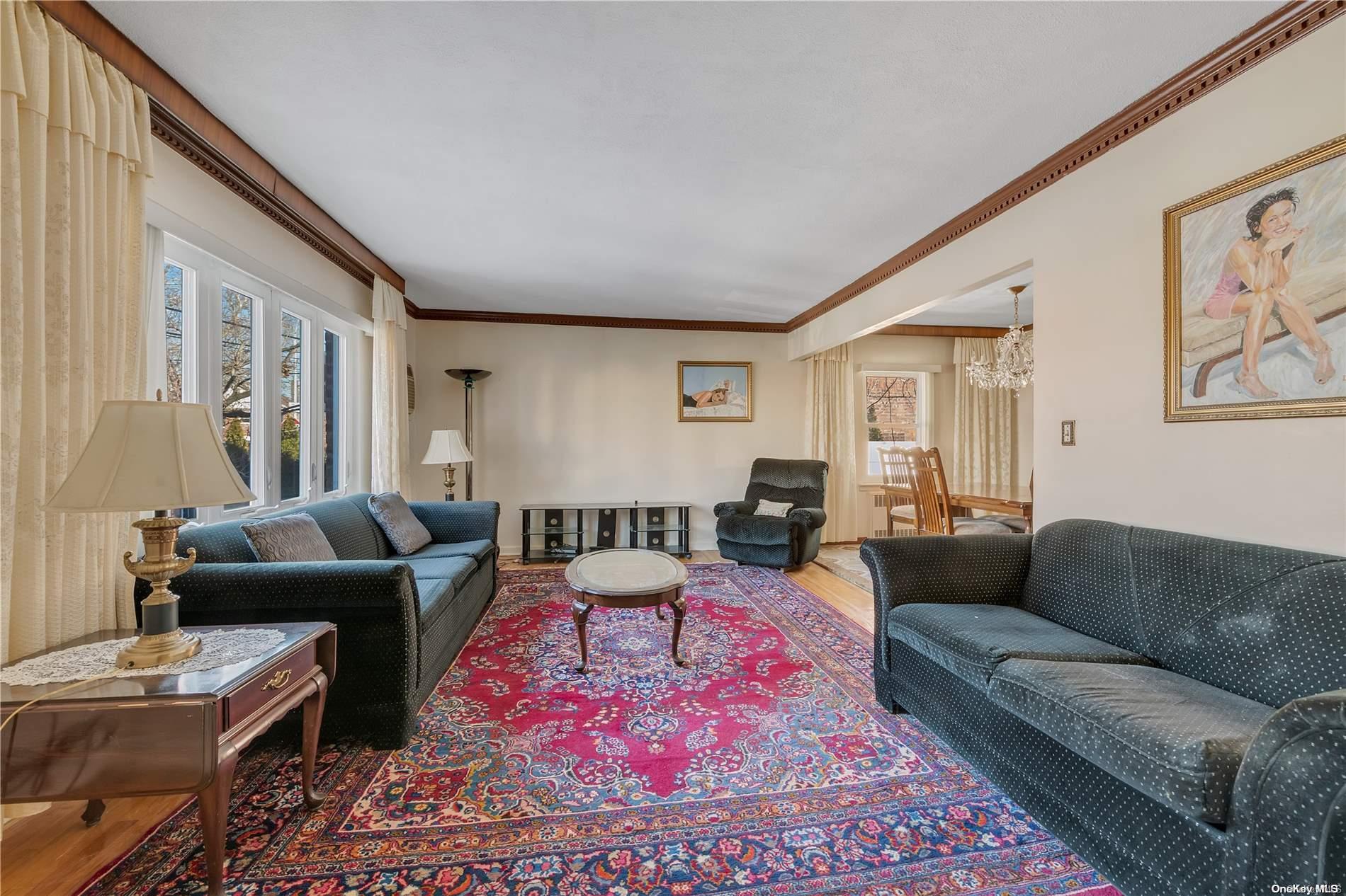 166-40 15th Drive Queens, NY 11357 - Photo 2 of 28 a living room with furniture a rug and a window