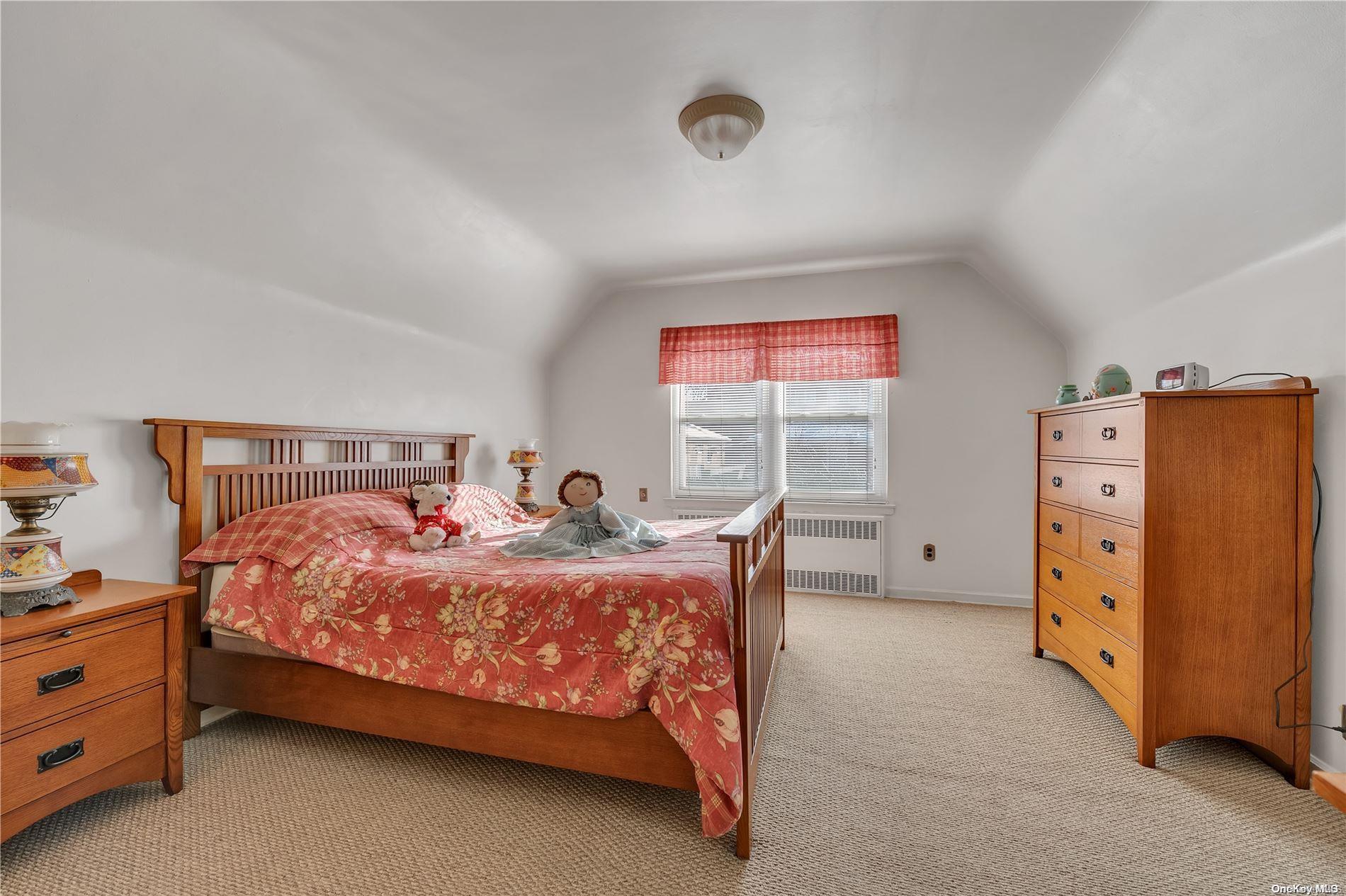 166-40 15th Drive Queens, NY 11357 - Photo 21 of 28 a bed sitting in a bedroom next to a window with dresser and lamp