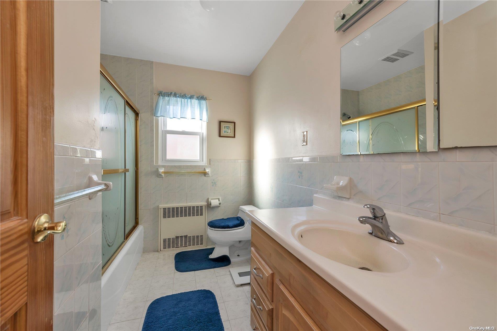 166-40 15th Drive Queens, NY 11357 - Photo 24 of 28 a bathroom with a sink and a large mirror