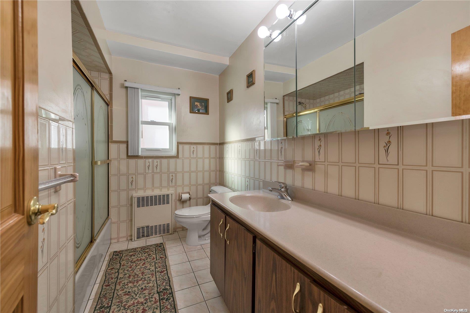 166-40 15th Drive Queens, NY 11357 - Photo 9 of 28 a bathroom with a sink a toilet and shower