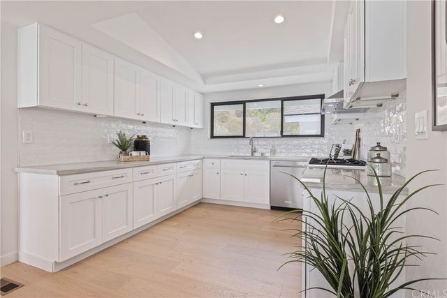 a kitchen with white cabinets and a sink