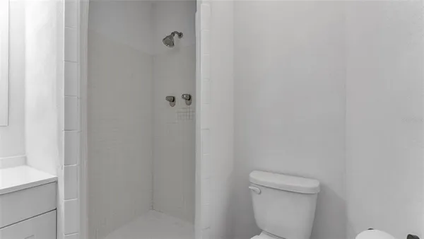 a bathroom with a toilet and a shower