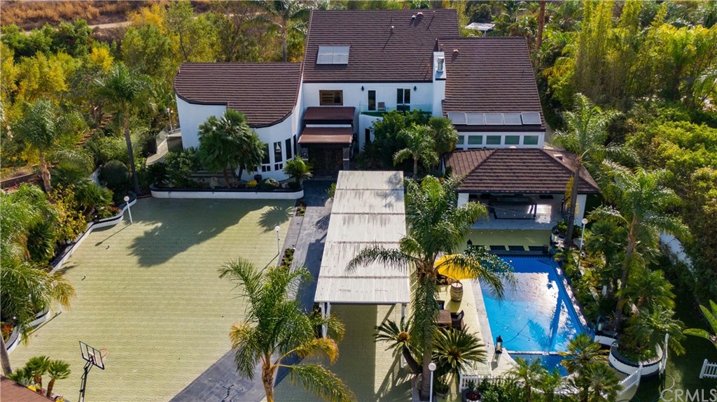 an aerial view of a house with swimming pool and garden