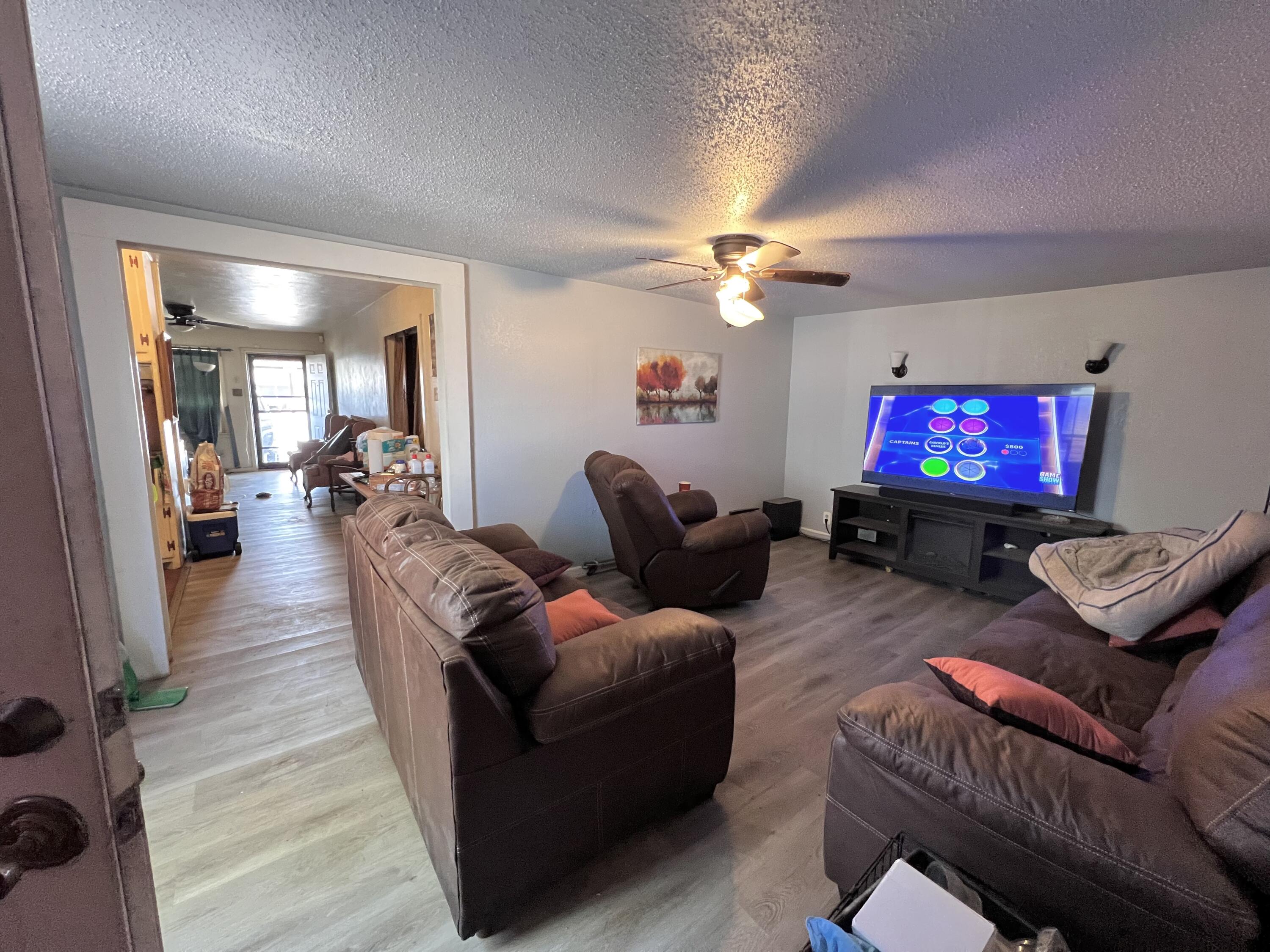1801 East 2nd Street Lubbock, TX 79403 - Photo 2 of 7 a living room with furniture a fireplace and a flat screen tv