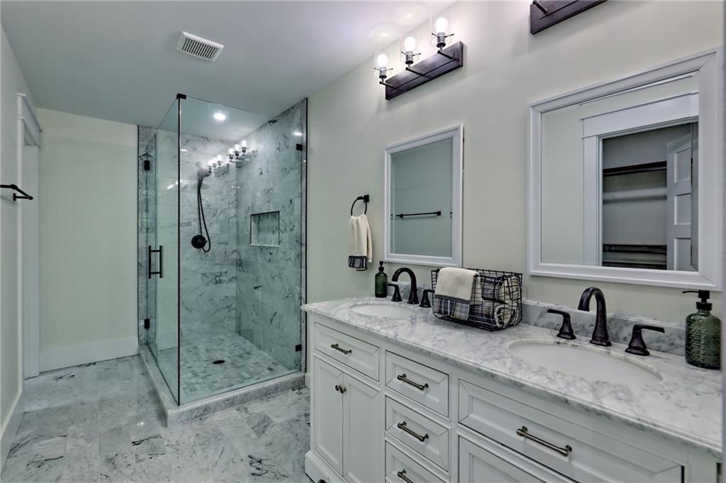 63 Redwood Lane Tiger, GA 30576 - Photo 32 of 77 a bathroom with a granite countertop sink a mirror a shower and a bathtub