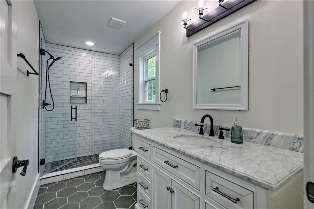 63 Redwood Lane Tiger, GA 30576 - Photo 53 of 77 a bathroom with a granite countertop sink toilet and shower