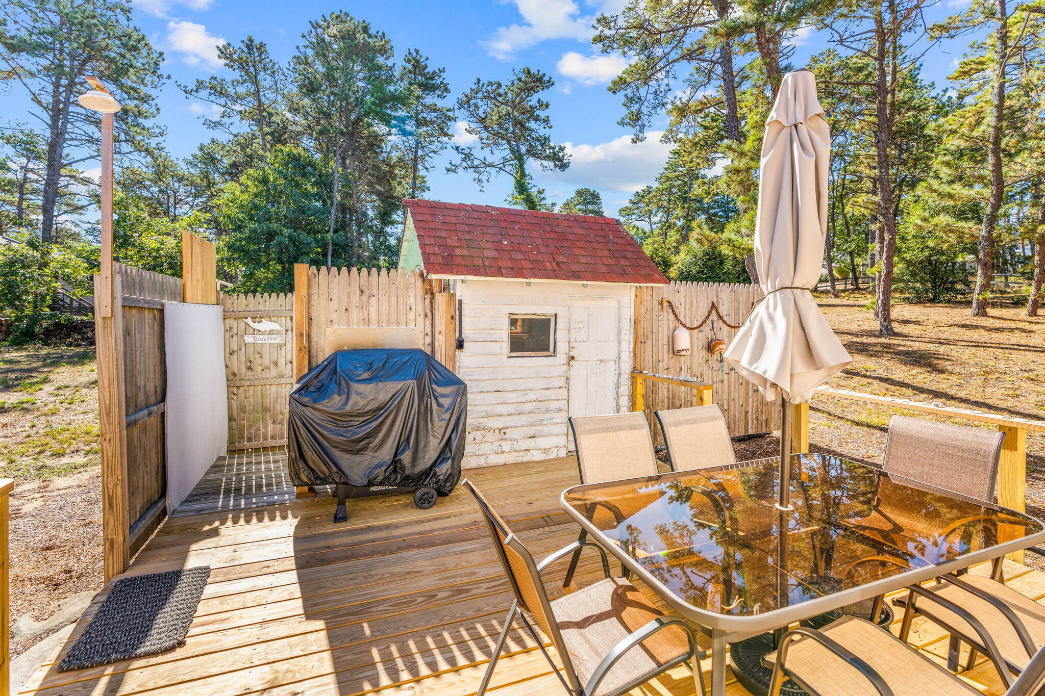 45 Indian Neck Road Wellfleet, MA 02667 - Photo 29 of 68 a view of a patio with table and chairs and wooden floor