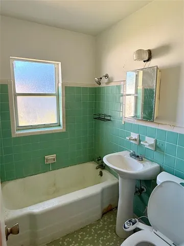 a view of an empty room with closet and a window