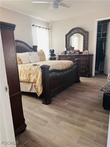 a spacious bedroom with a bed a mirror and dresser