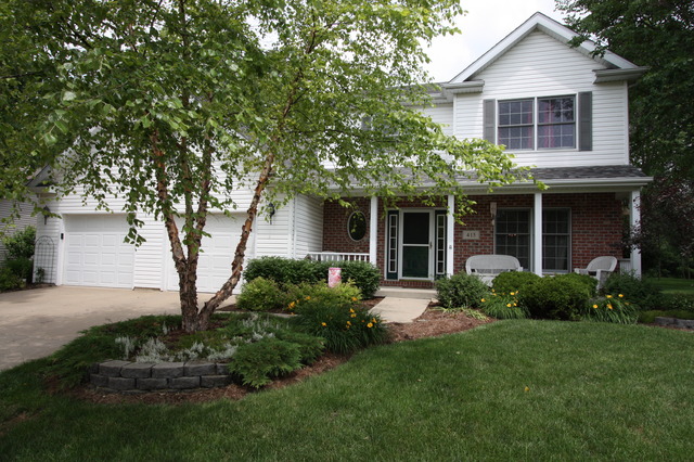 415 Rivers Edge Drive Minooka, IL 60447 - Photo 23 of 24 a front view of a house with a garden and plants