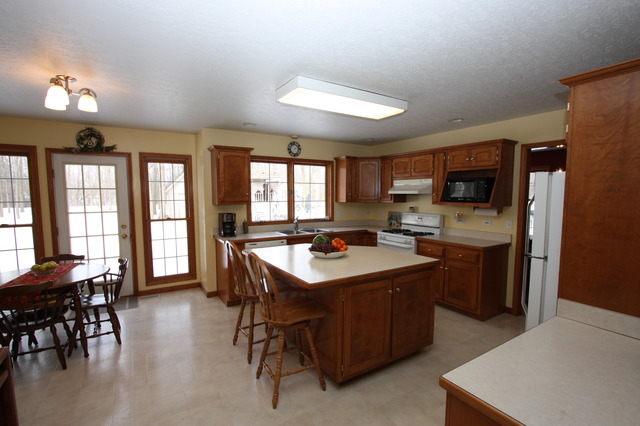 415 Rivers Edge Drive Minooka, IL 60447 - Photo 4 of 24 a kitchen with a stove a refrigerator a dining table and chairs