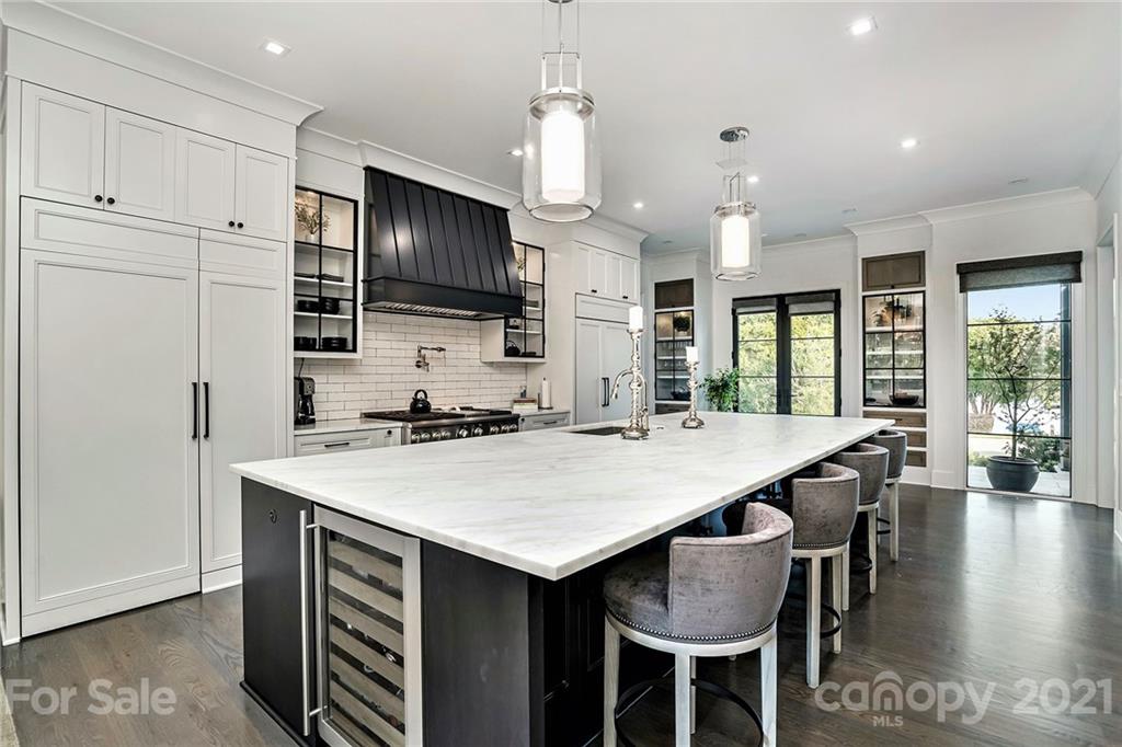 19053 Double Eagle Drive Cornelius, NC 28031 - Photo 11 of 43 a kitchen with kitchen island a stove a table and chairs in it