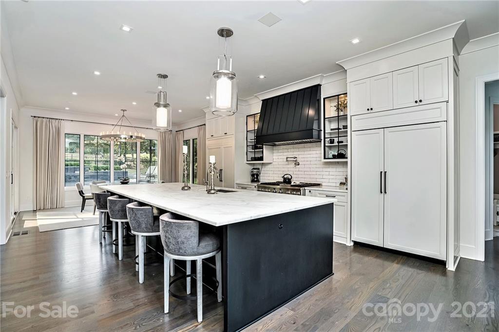 19053 Double Eagle Drive Cornelius, NC 28031 - Photo 10 of 43 a kitchen with kitchen island a dining table chairs and white appliances