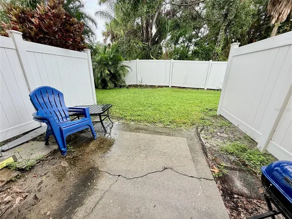 a view of a backyard with a chair and a white house