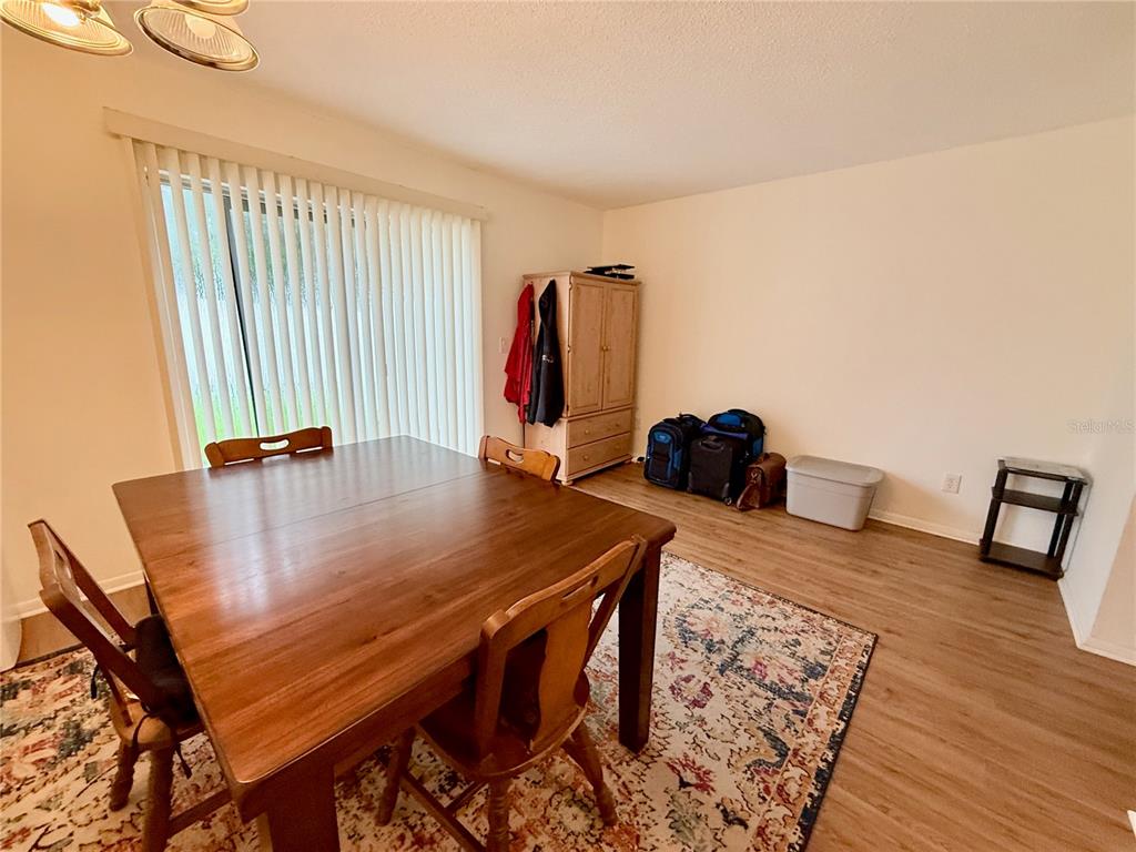 4805 Rilma Avenue, Unit 102 Sarasota, FL 34234 - Photo 3 of 18 a view of a dining room with furniture and wooden floor