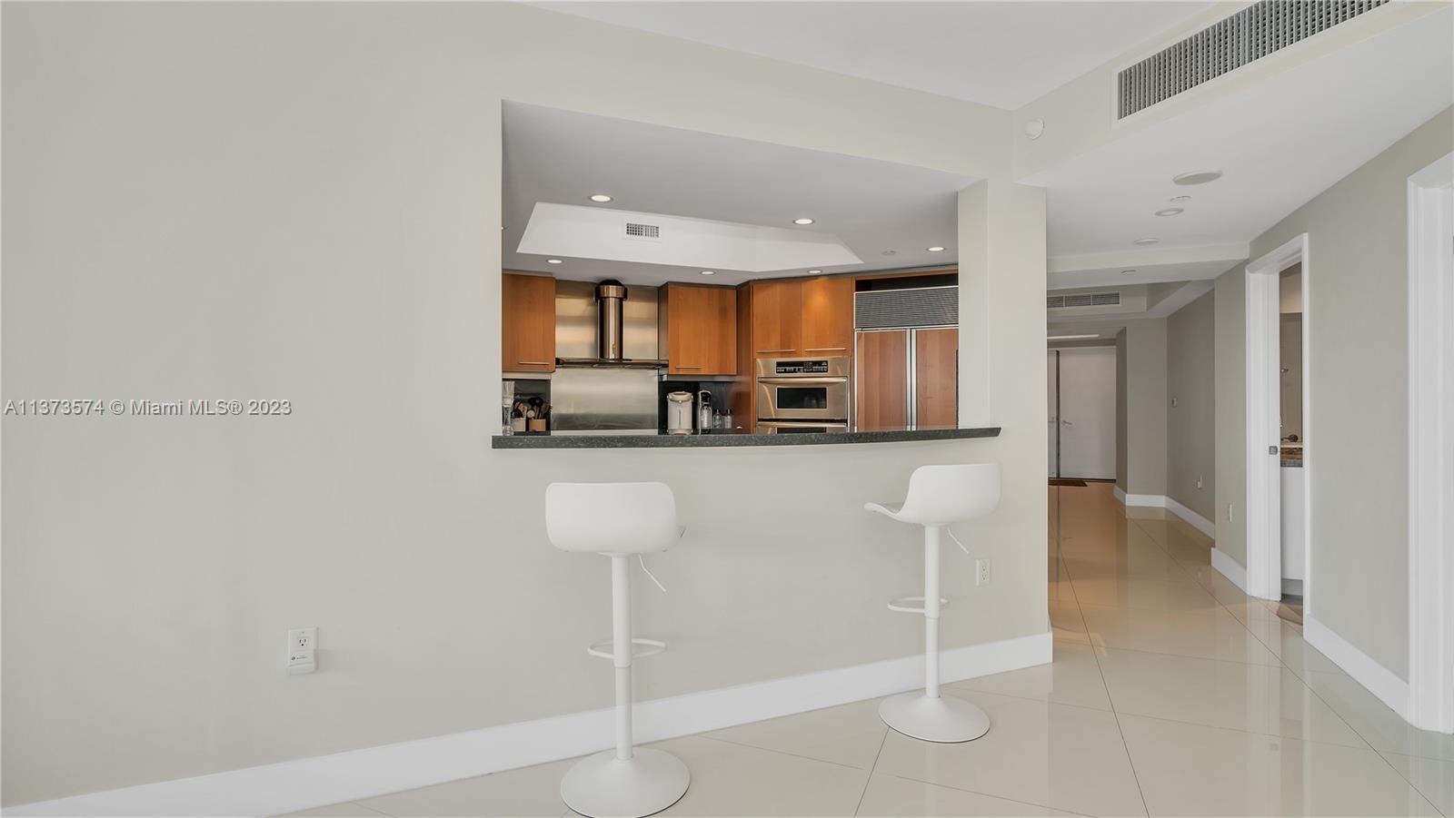 9401 Collins Avenue, Unit 402 Surfside, FL 33154 - Photo 11 of 31 a kitchen with stainless steel appliances a refrigerator and microwave