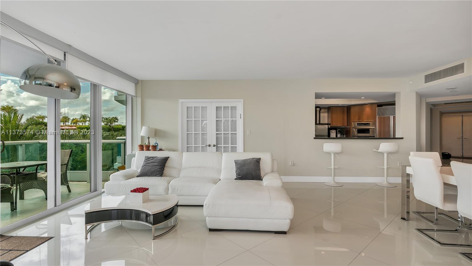 9401 Collins Avenue, Unit 402 Surfside, FL 33154 - Photo 15 of 31 a bedroom with furniture and a flat screen tv