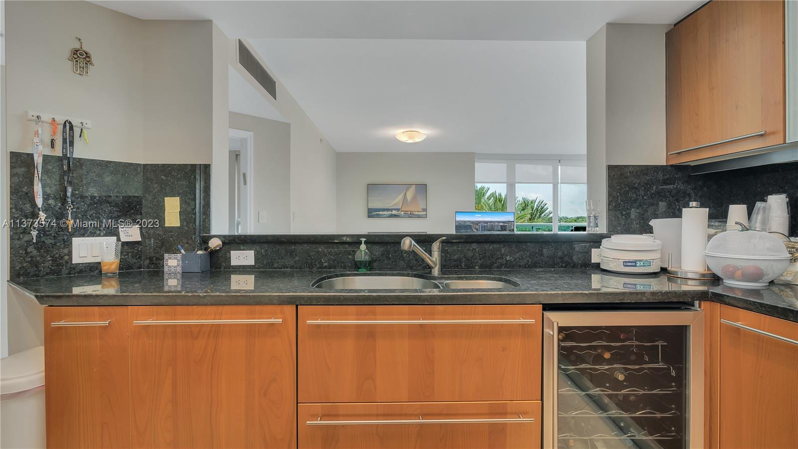 9401 Collins Avenue, Unit 402 Surfside, FL 33154 - Photo 18 of 31 a kitchen with granite countertop a sink and cabinets
