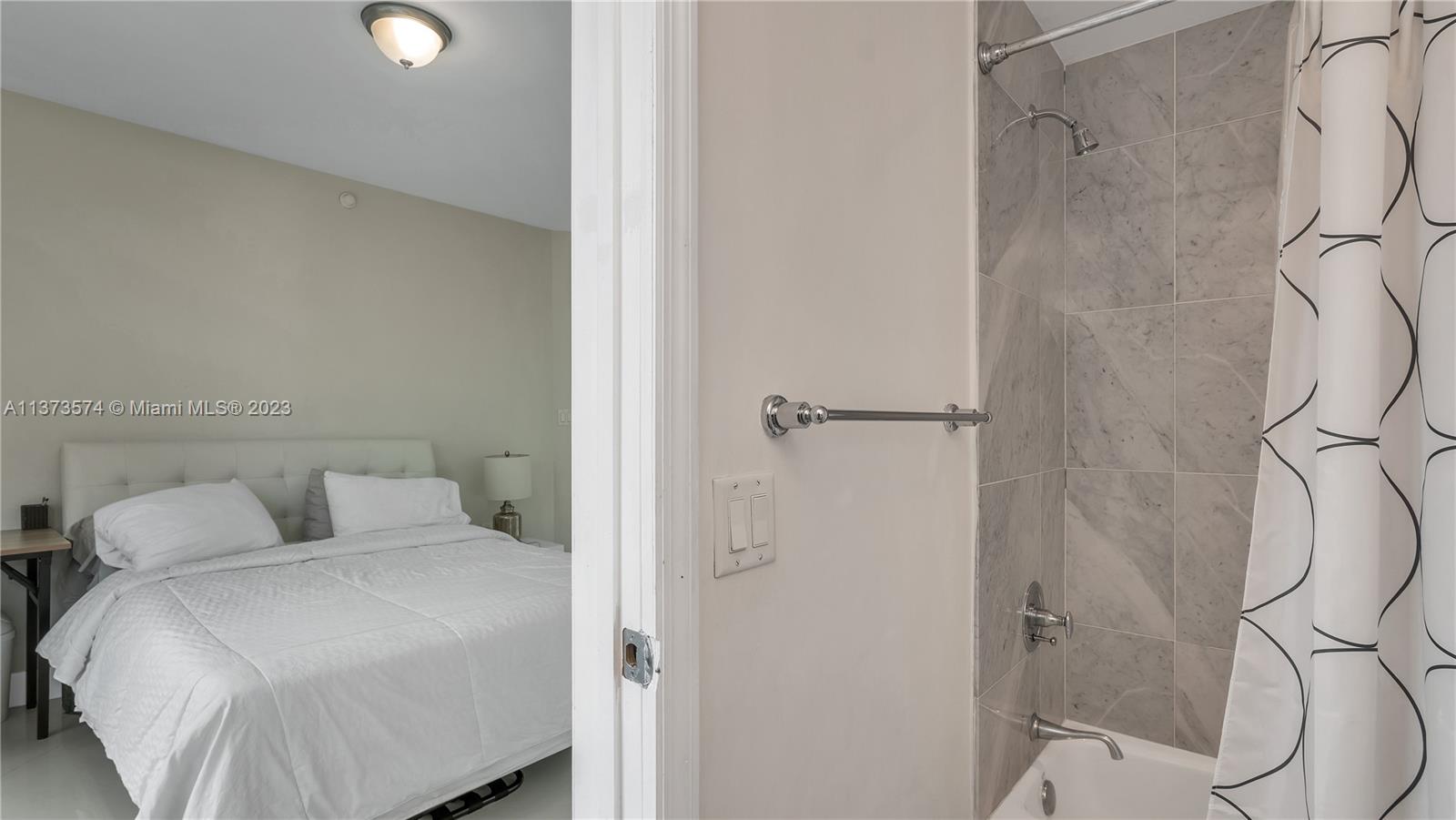 9401 Collins Avenue, Unit 402 Surfside, FL 33154 - Photo 19 of 31 a bedroom with a bed and a shower