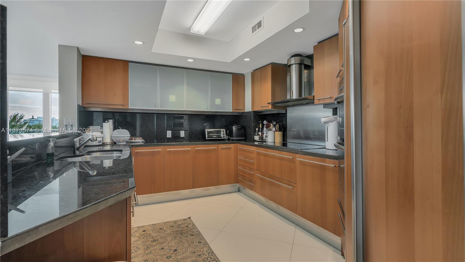 9401 Collins Avenue, Unit 402 Surfside, FL 33154 - Photo 2 of 31 a kitchen with stainless steel appliances granite countertop a stove a sink and a refrigerator