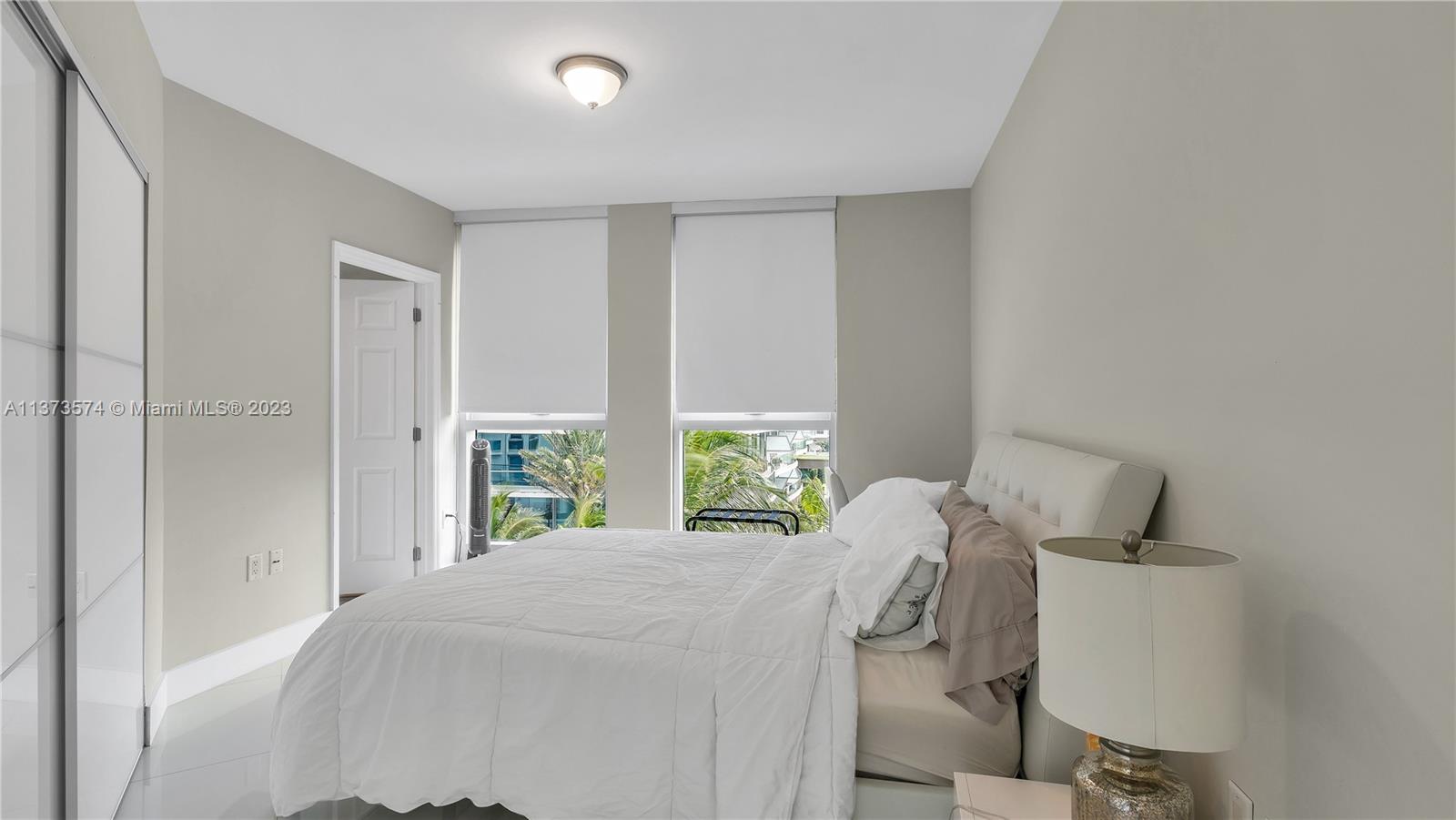 9401 Collins Avenue, Unit 402 Surfside, FL 33154 - Photo 24 of 31 a bedroom with a bed and a window