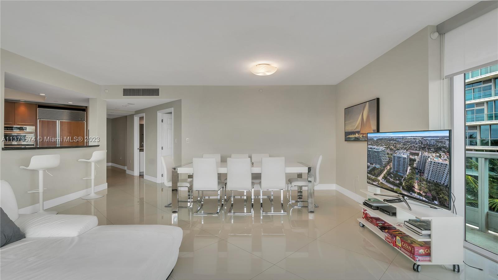 9401 Collins Avenue, Unit 402 Surfside, FL 33154 - Photo 25 of 31 a living room with furniture a fireplace and a flat screen tv