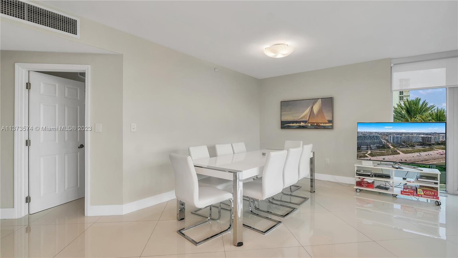 9401 Collins Avenue, Unit 402 Surfside, FL 33154 - Photo 3 of 31 a living room with furniture and a flat screen tv