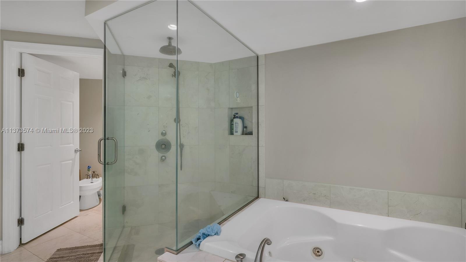 9401 Collins Avenue, Unit 402 Surfside, FL 33154 - Photo 5 of 31 a bathroom with a tub and shower