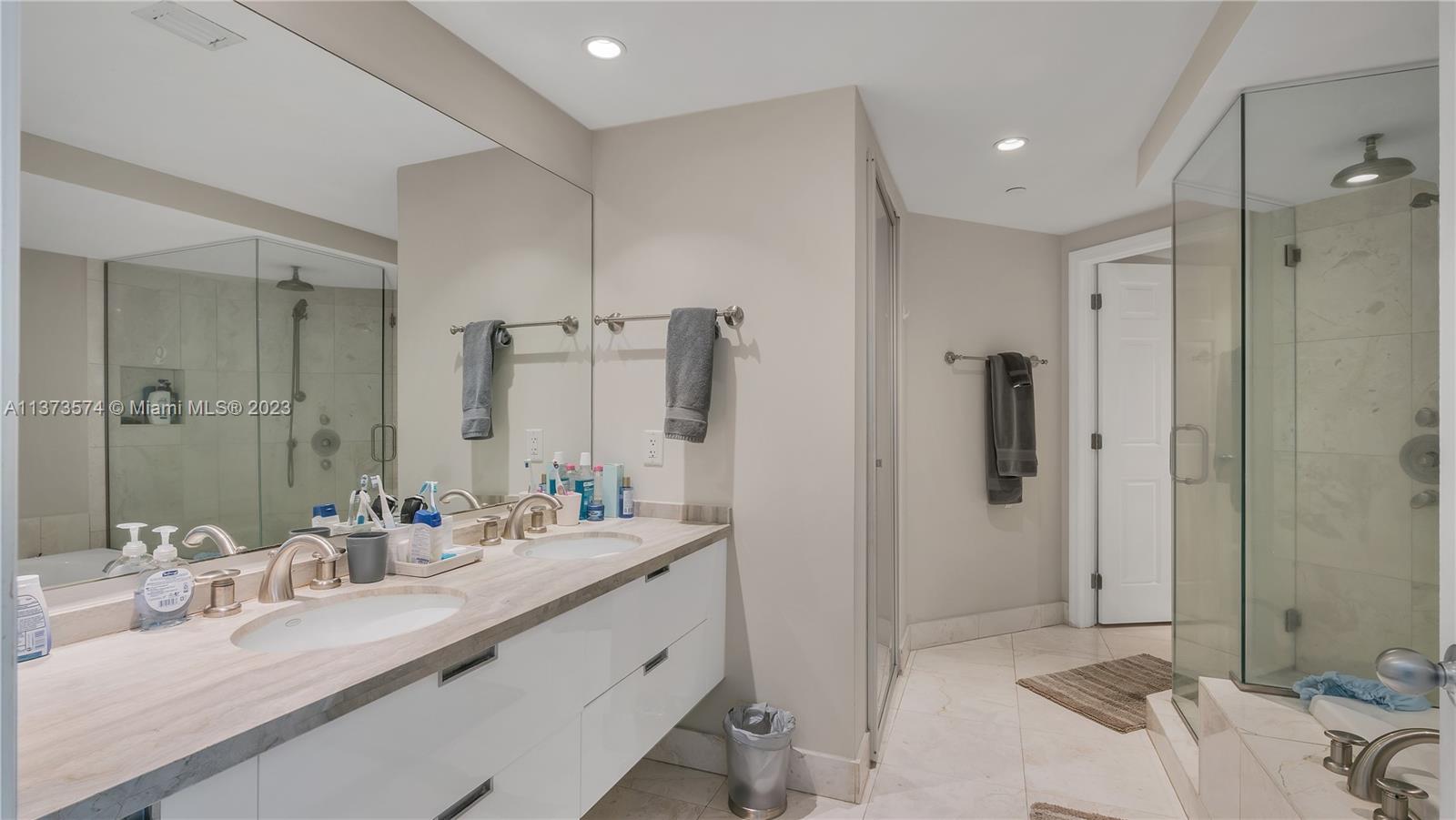 9401 Collins Avenue, Unit 402 Surfside, FL 33154 - Photo 7 of 31 a bathroom with double vanity sinks and a shower