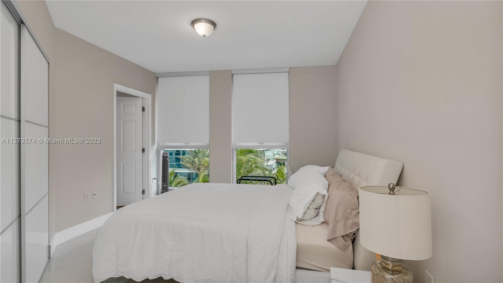 9401 Collins Avenue, Unit 402 Surfside, FL 33154 - Photo 10 of 31 a bedroom with a bed and a window