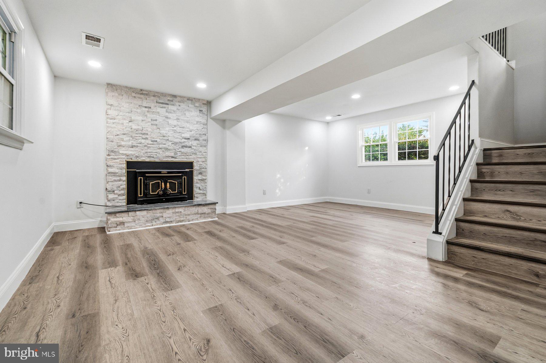 6301 Linus Drive Baltimore, MD 21207 - Photo 31 of 38 an empty room with wooden floor fireplace and windows