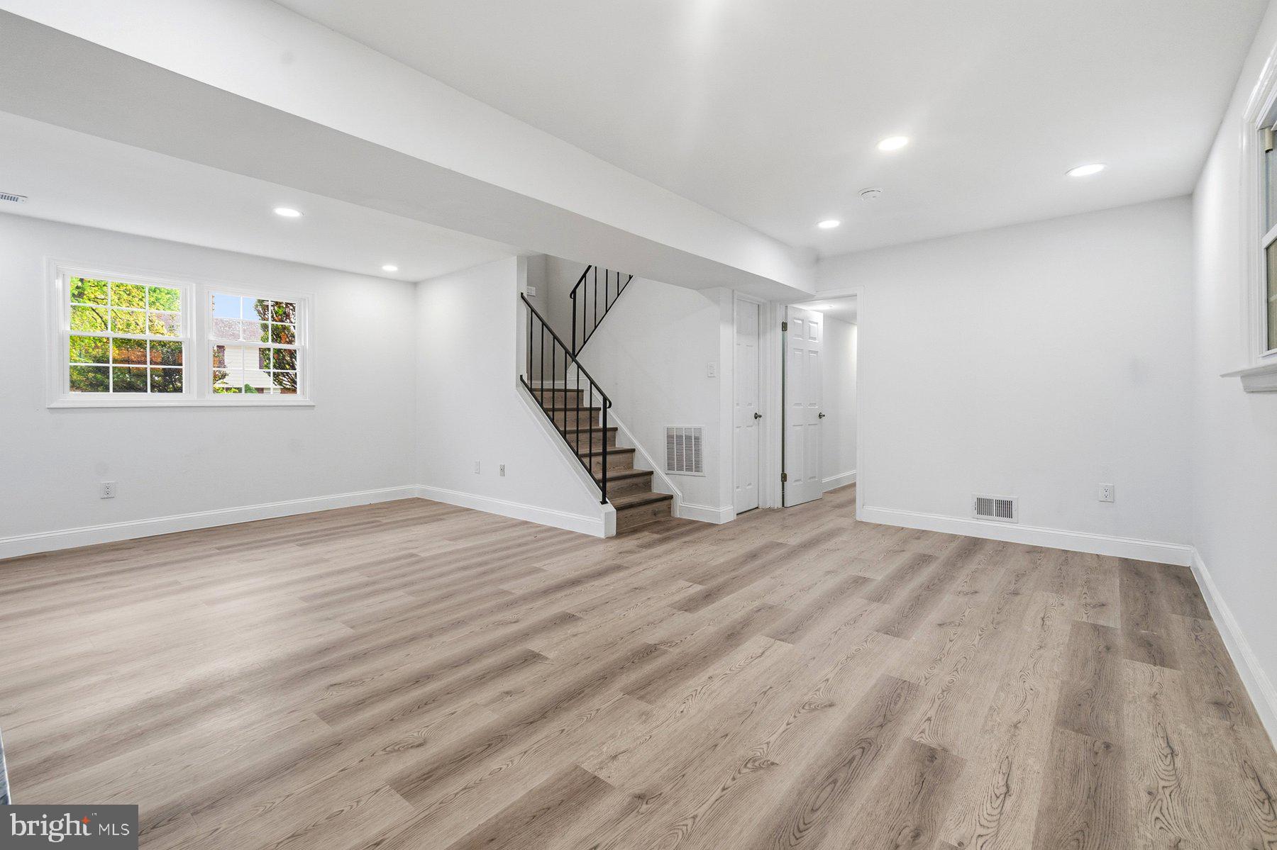 6301 Linus Drive Baltimore, MD 21207 - Photo 33 of 38 a view of an empty room with wooden floor and stairs