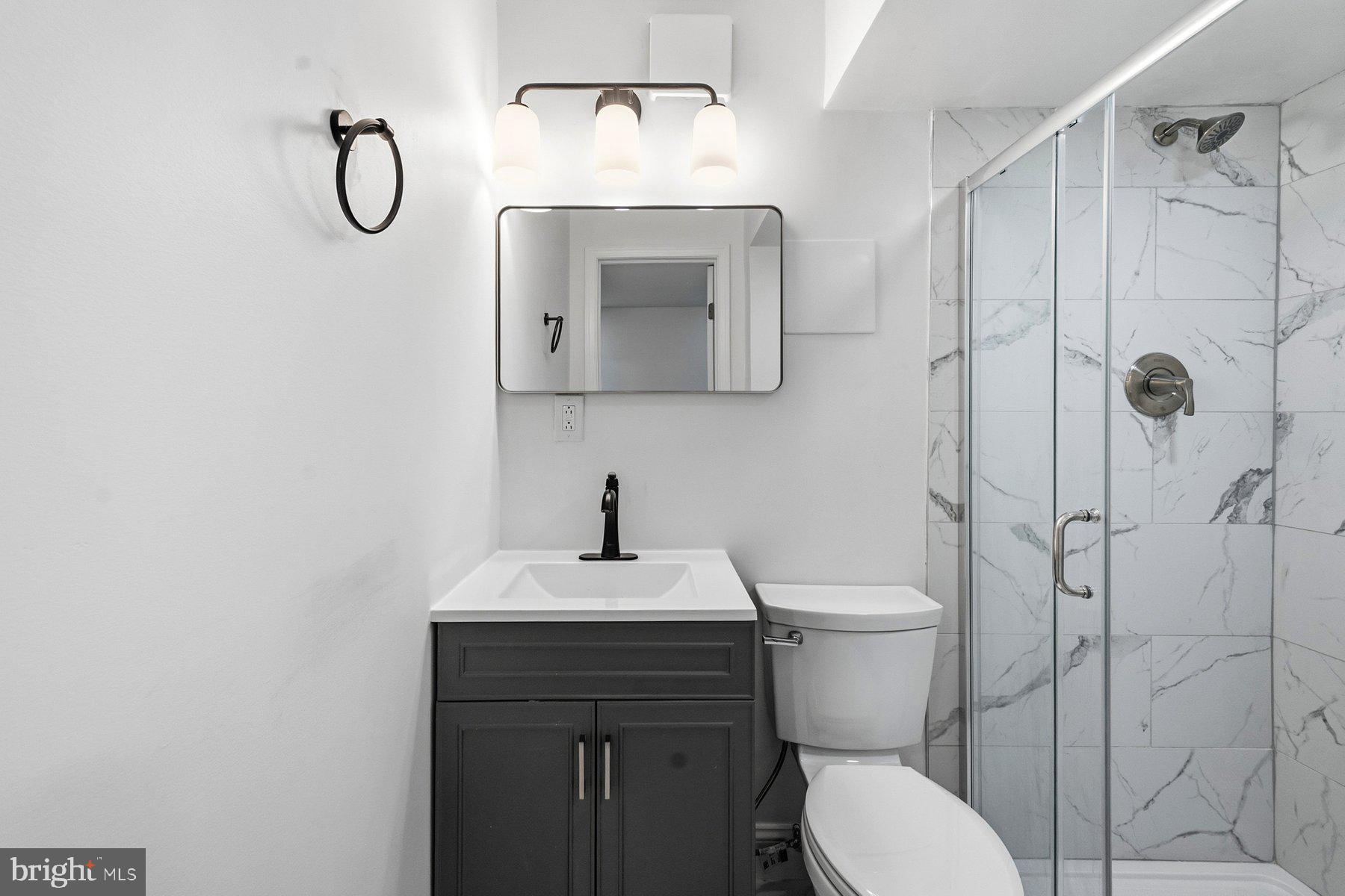 6301 Linus Drive Baltimore, MD 21207 - Photo 36 of 38 a bathroom with a toilet sink vanity and shower