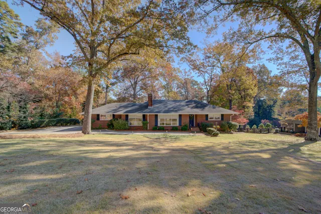 a view of a house with a large tree in front of it