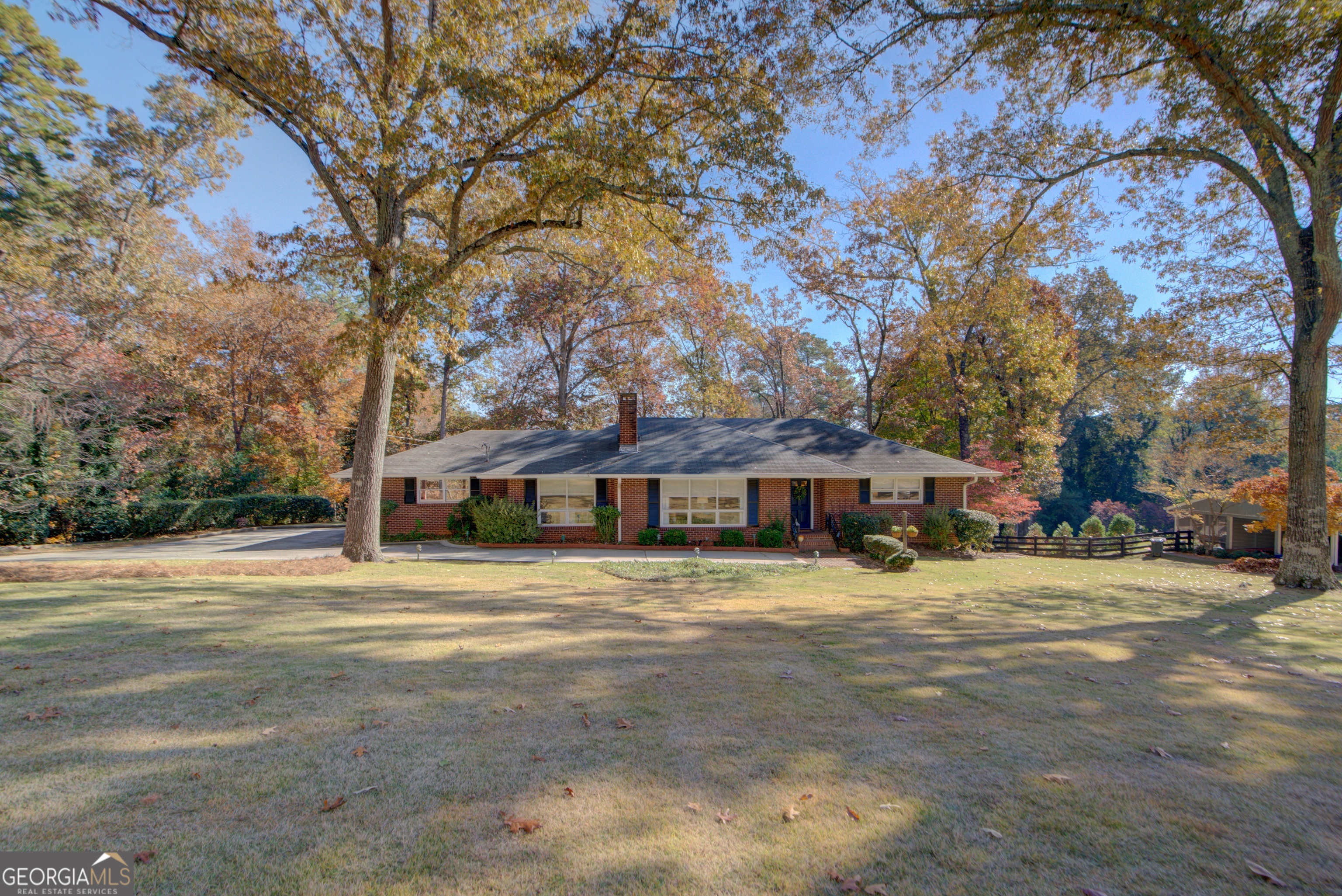 a view of a house with a large tree in front of it