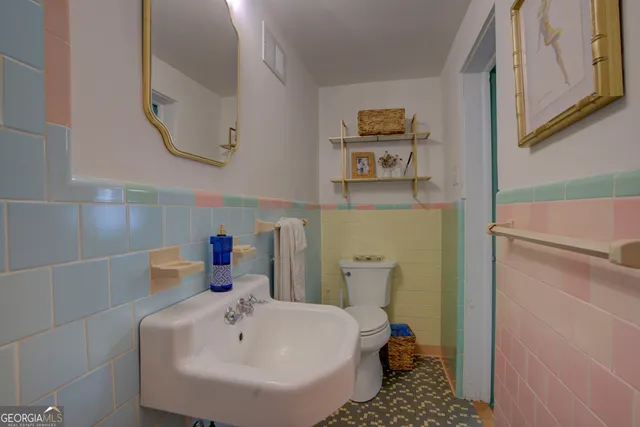 a bathroom with a sink toilet and a mirror
